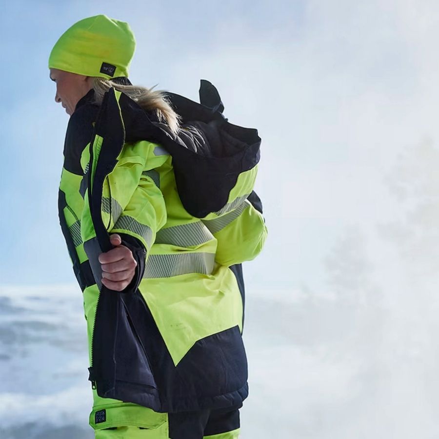 Arbeidstaker i kulde med vinterarbeidsklær, hansker og beskyttelse mot vind, fukt og lave temperaturer.